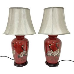 Pair of large table lamps of tapering form, decorated with cranes upon a red ground, upon circular footed base, H68cm