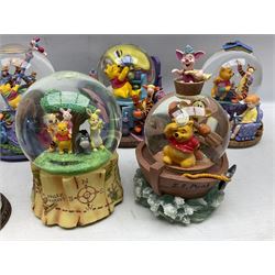 Five Disney Winnie The Pooh snow globes, to include Pooh and Piglet Sailing, Pooh's Grand Adventure and Blustery Day, together with The Walt Disney Classic Waterglobe collection globe and group Tigger, Winnie and Piglet figure under dome, all with boxes (7)