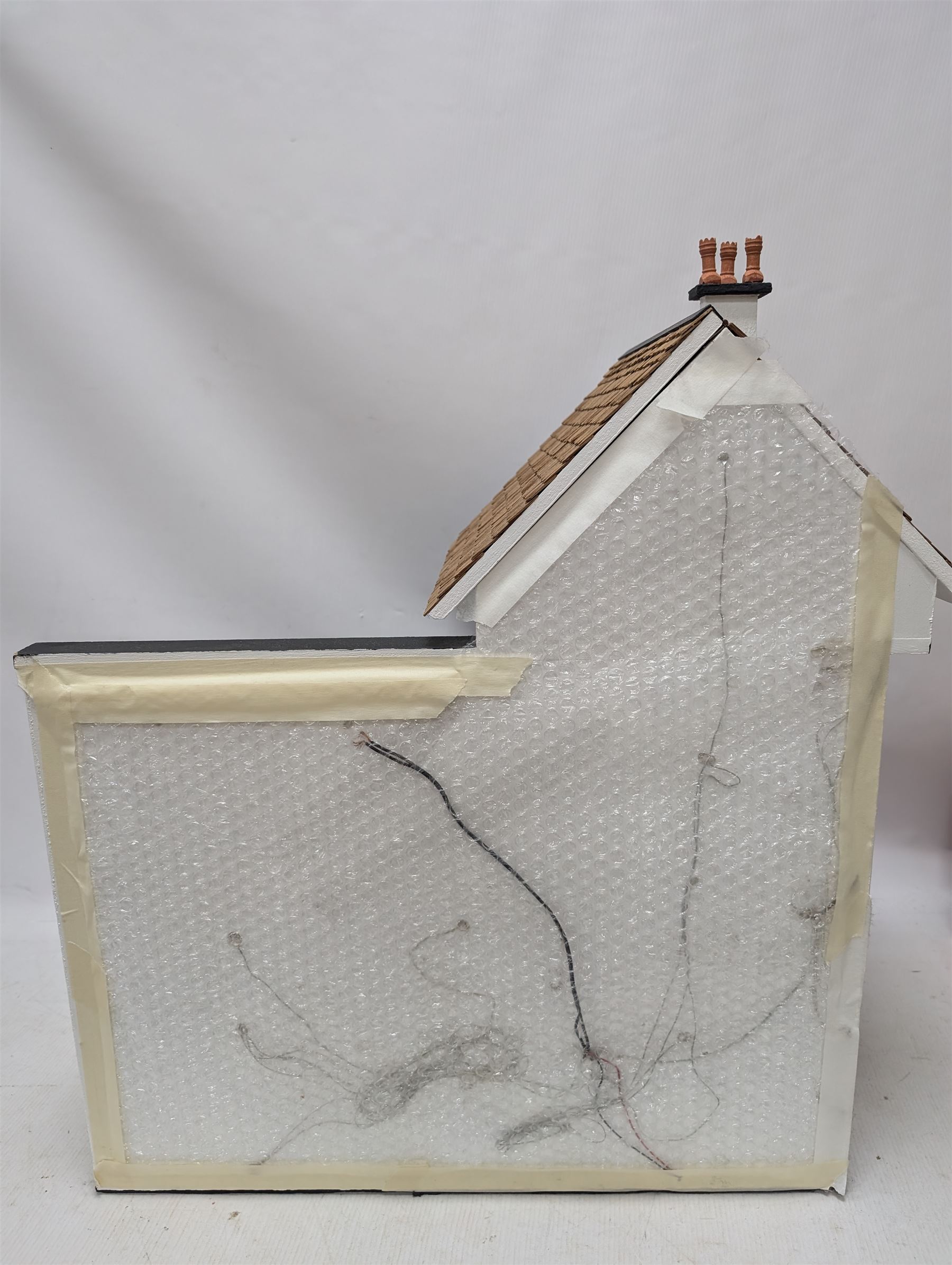 1:24 scale four-storey tudor-style dolls house, with black and white exterior, balcony garden, glazed panelled windows and wooden shingle roof, with decorated interior and wired fireplaces and lighting, H65cm, W58cm, D31cm, 