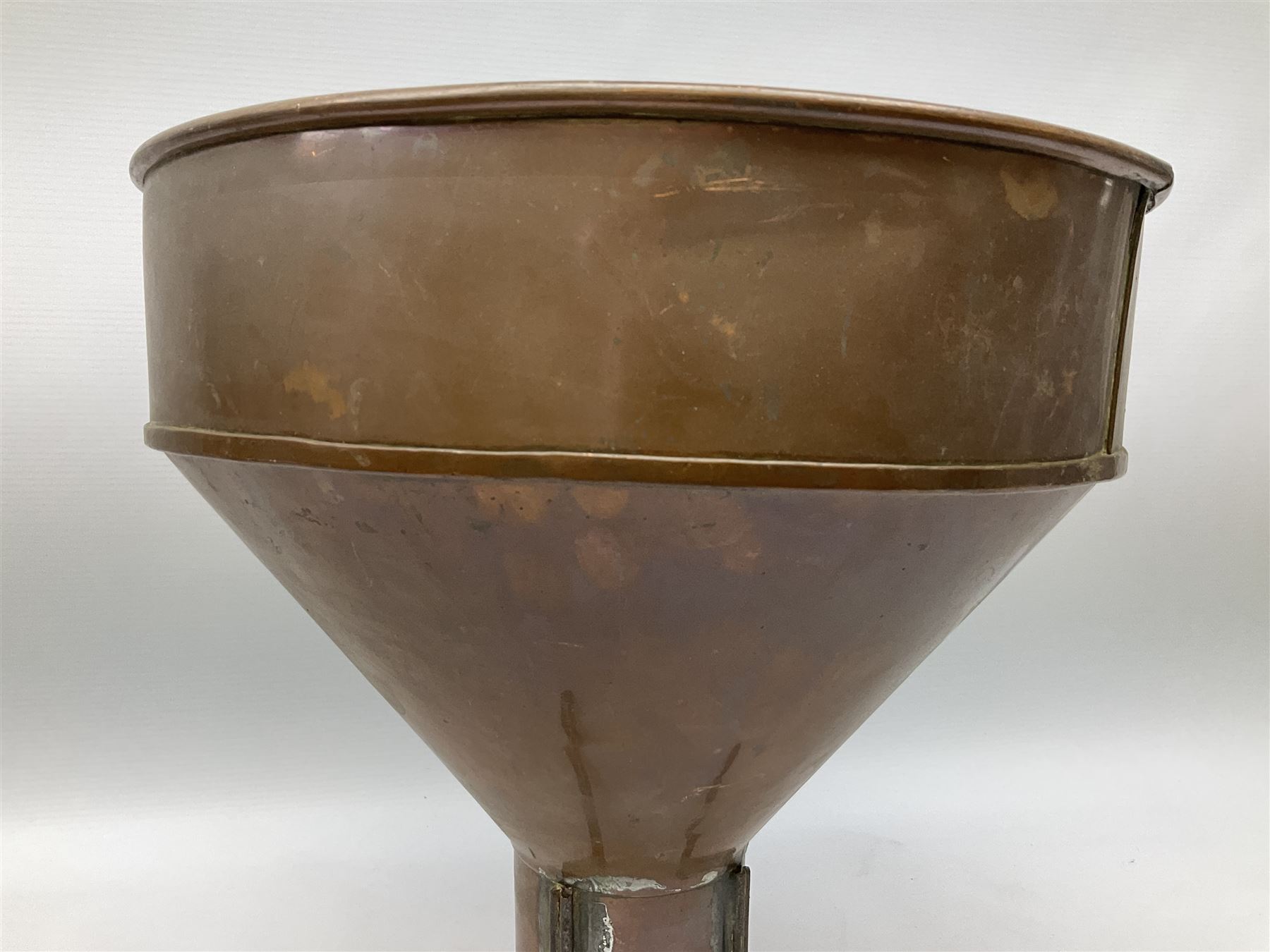 Agricultural copper corn funnel, H32.5cm, another similar copper funnel and copper warming platter of oval form, with twin handles on four supports, with removeable warming plate, L49cm