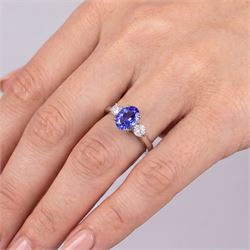 Platinum tanzanite and diamond three stone ring, single oval cut tanzanite of approx 3.55 carat, with a round brilliant cut diamond set either side, total diamond weight approx 0.80 carat