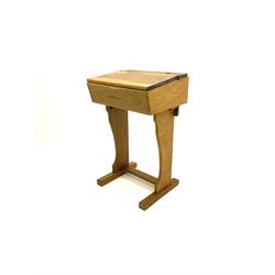 Early 20th century narrow oak school desk, fitted with ink well and hinge lid enclosing book compartment, raised on shaped supports and sledge feet joined by floor stretcher 