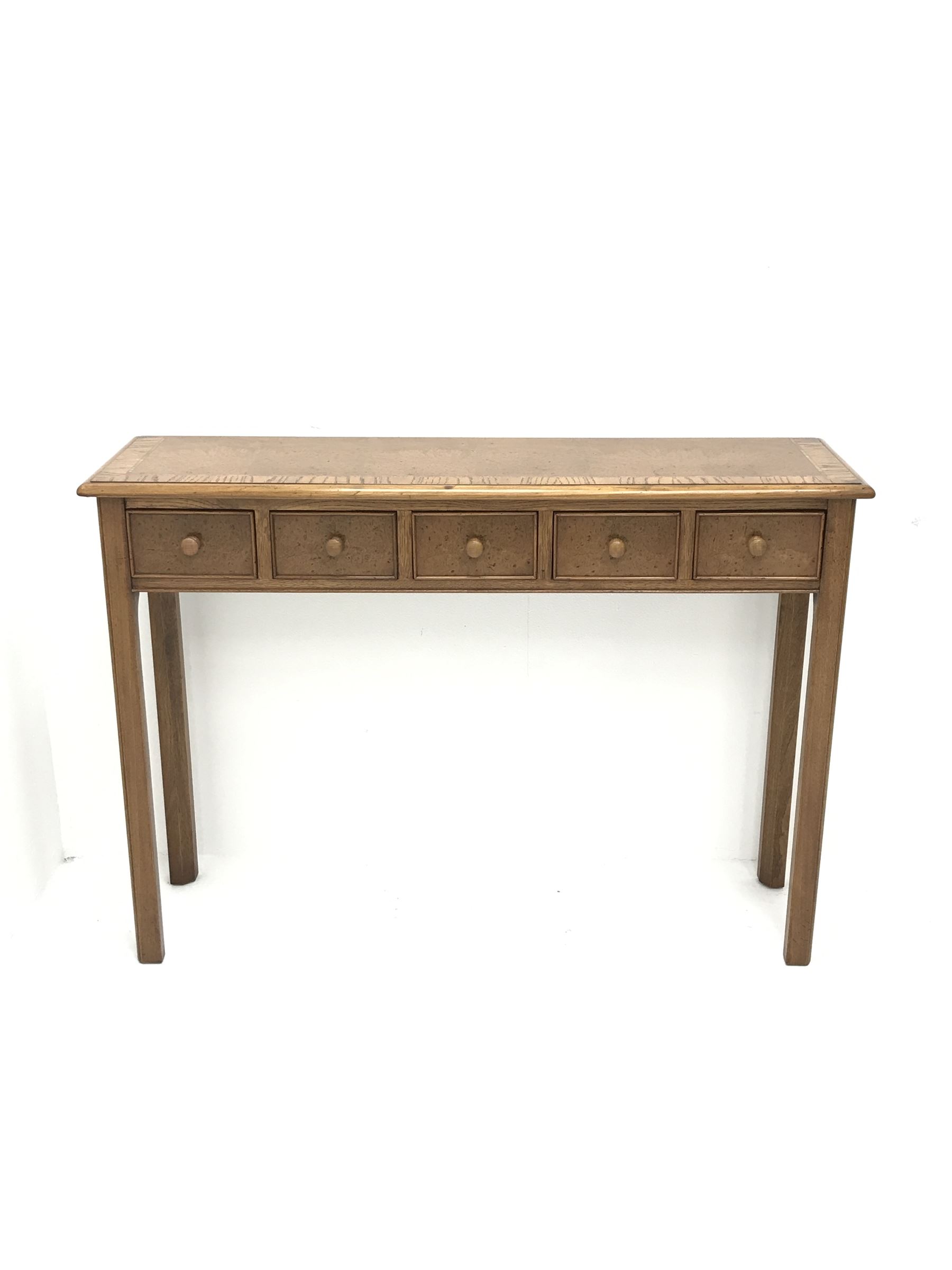 Contemporary oak, mahogany, and figured burr walnut narrow console table, moulded rectangular top with oak band and satinwood stringing, five cock beeded short drawers with turned handles, moulded and canted square supports 