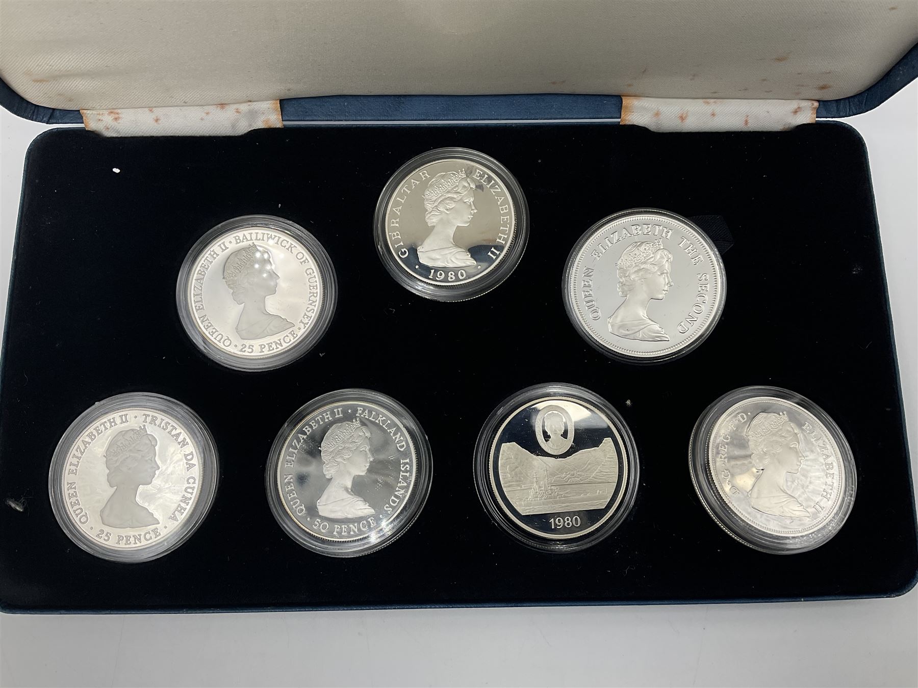 The Royal Mint silver proof seven coin set, comprising United Kingdom and six Commonwealth crowns, commemorating 'Her Majesty Queen Elizabeth The Queen Mother's 80th Birthday', cased with certificate