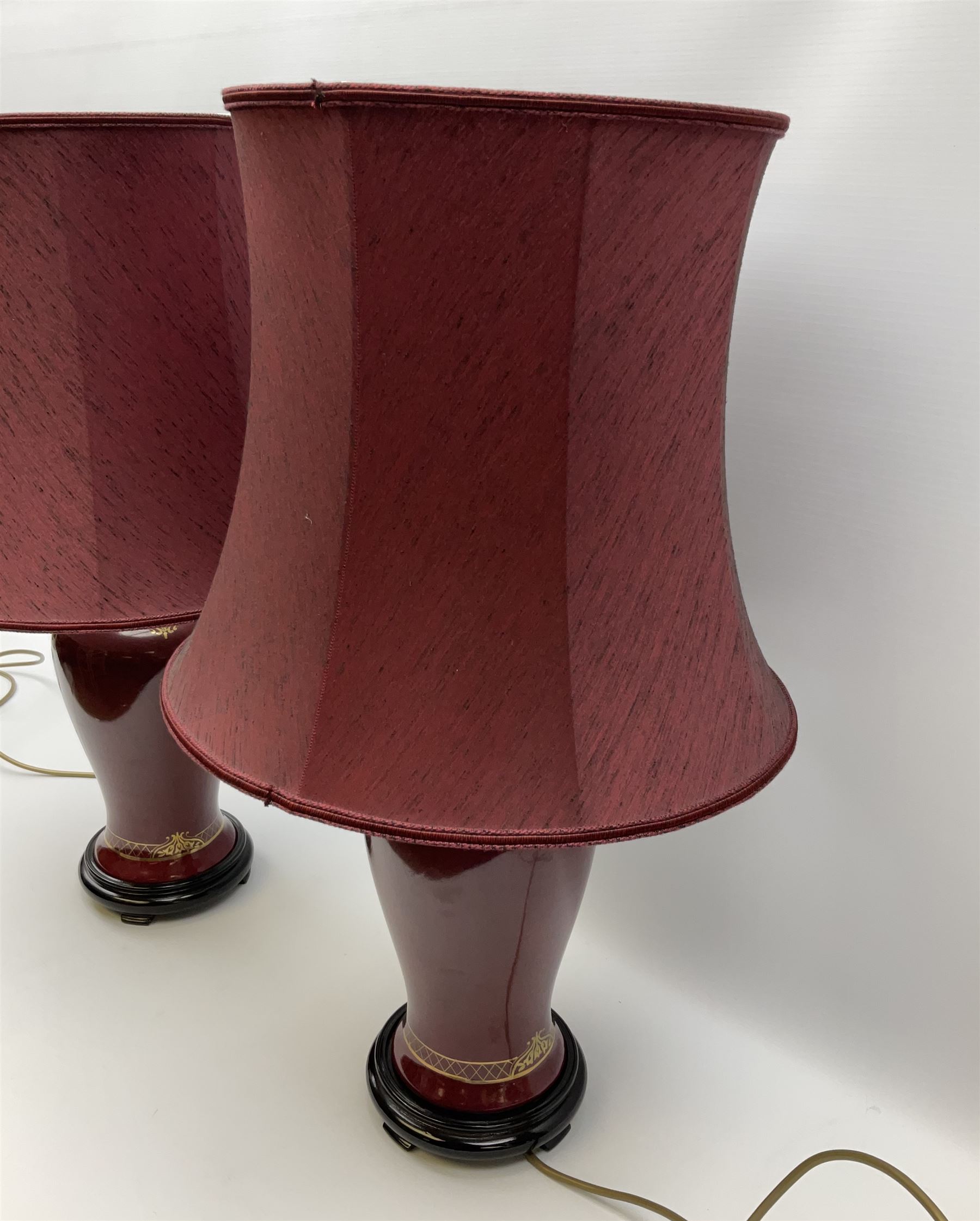 Pair of dark red table lamps in baluster form with a round wooden