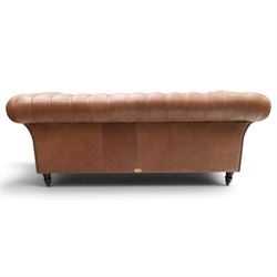 Distinctive Chesterfield - full buttoned tan brown leather sofa, deep buttoned back, seat and arms, raised on dark stained supports terminating in brass castors 