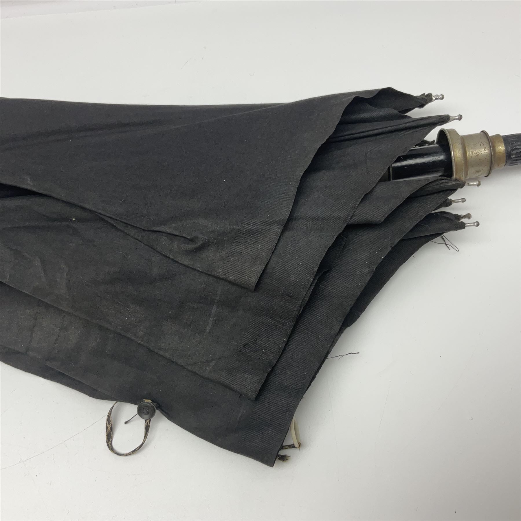 Early 20th century Indian ebonised wooden umbrella sword stick with 36cm blade, carved bone mount and black cloth cover L92cm overall; together with a similar Indian ebonised wooden sword stick with 64cm blade, carved bone mount and brass lion mask pommel L91cm (2)