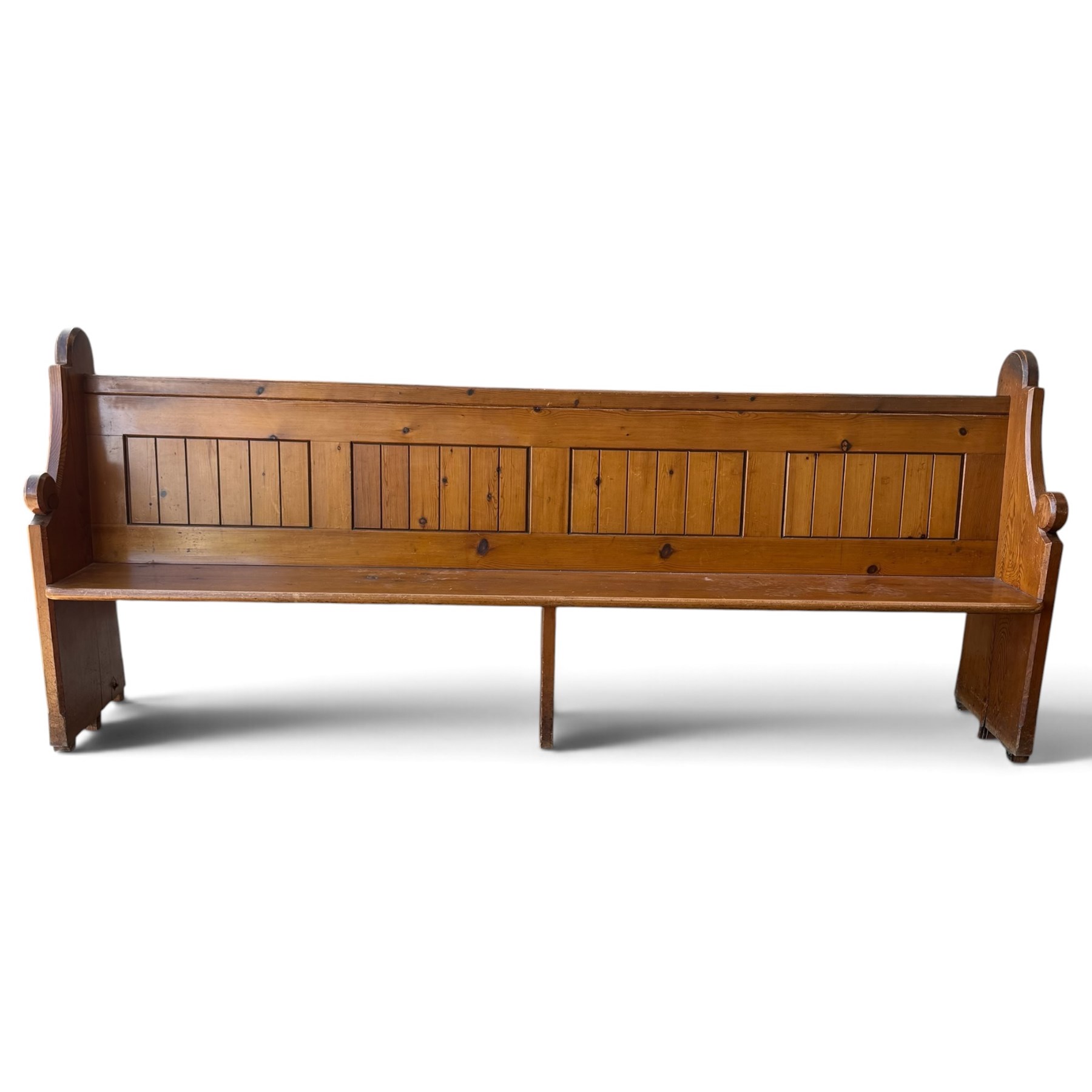 Early 20th century stained pine ecclesiastical church pew, the shaped end supports flanking slatted and panelled back, with black stencilled number '15' to the side