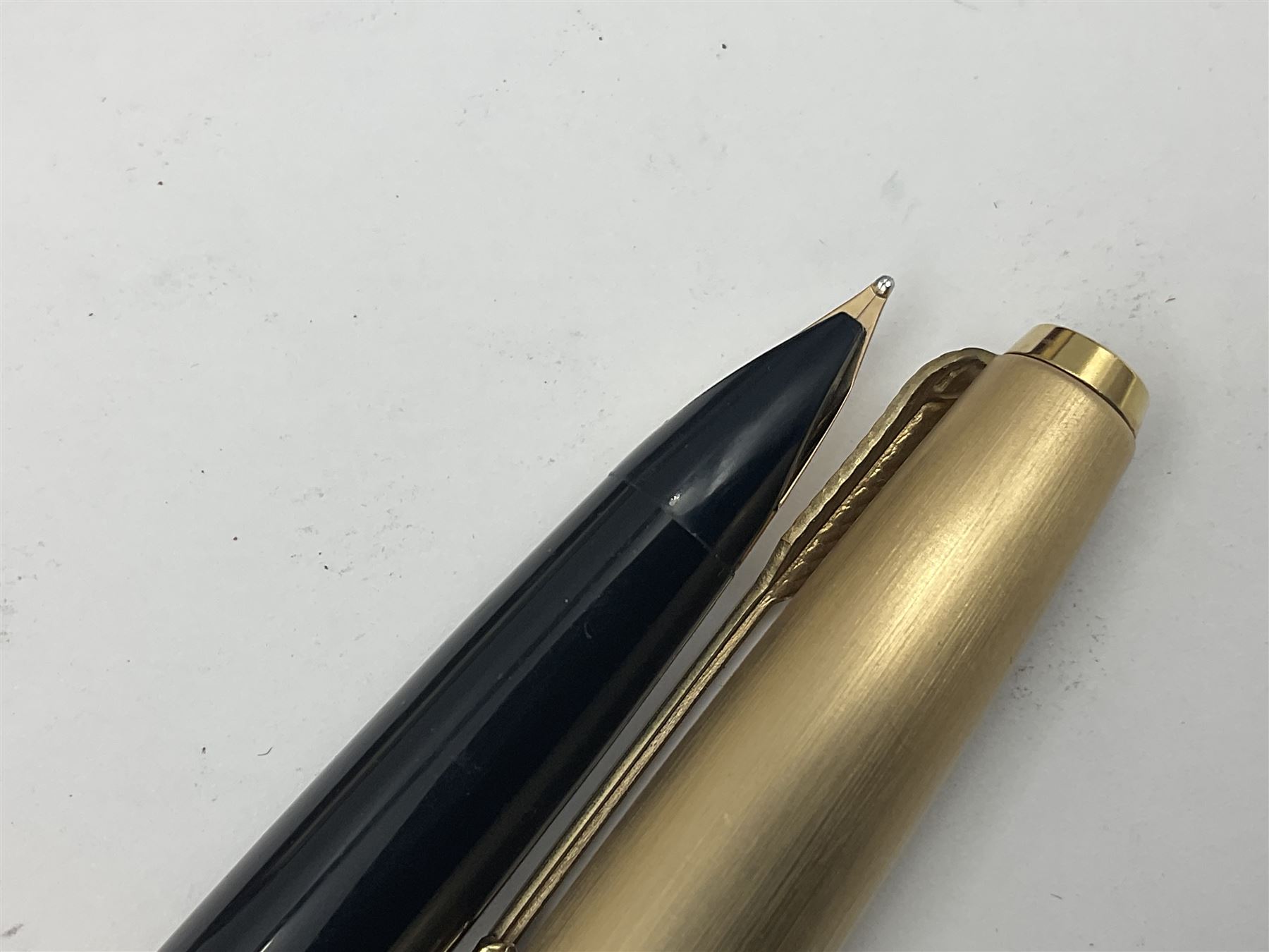 Three rolled gold Parker fountain pens, comprising an example with a gold nib marked 14K 585 and barrel with a shell stamp, a Parker 61 fountain pen with inset gold arrow to the nib, and another similar, all with striated decoration and arrow clips to the caps, L13cm, one with box