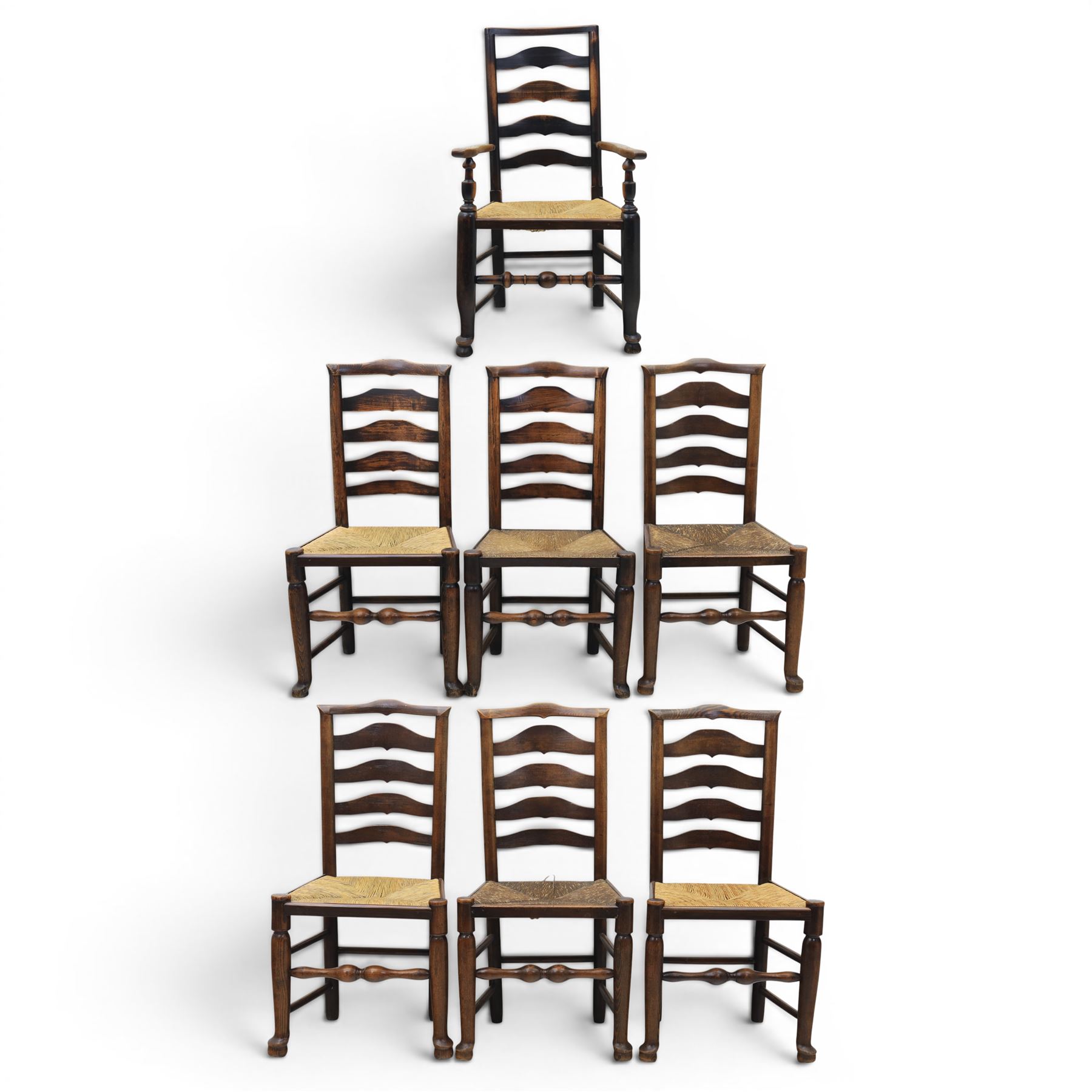 Set of seven (6+1) Georgian design country elm Lancashire dining chairs, ladder backs with rush seats, turned front leg stretcher on pad feet, height of seat 44cm, complete with fitted tie on cushions