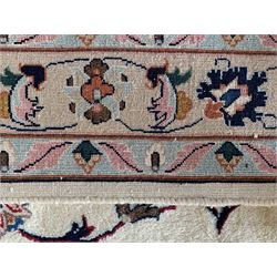 Large Persian Heriz carpet, ivory ground with trailing floral design and decorated with stylised flower heads, matching design to blue ground boarder, multiple guards with foliate decoration 