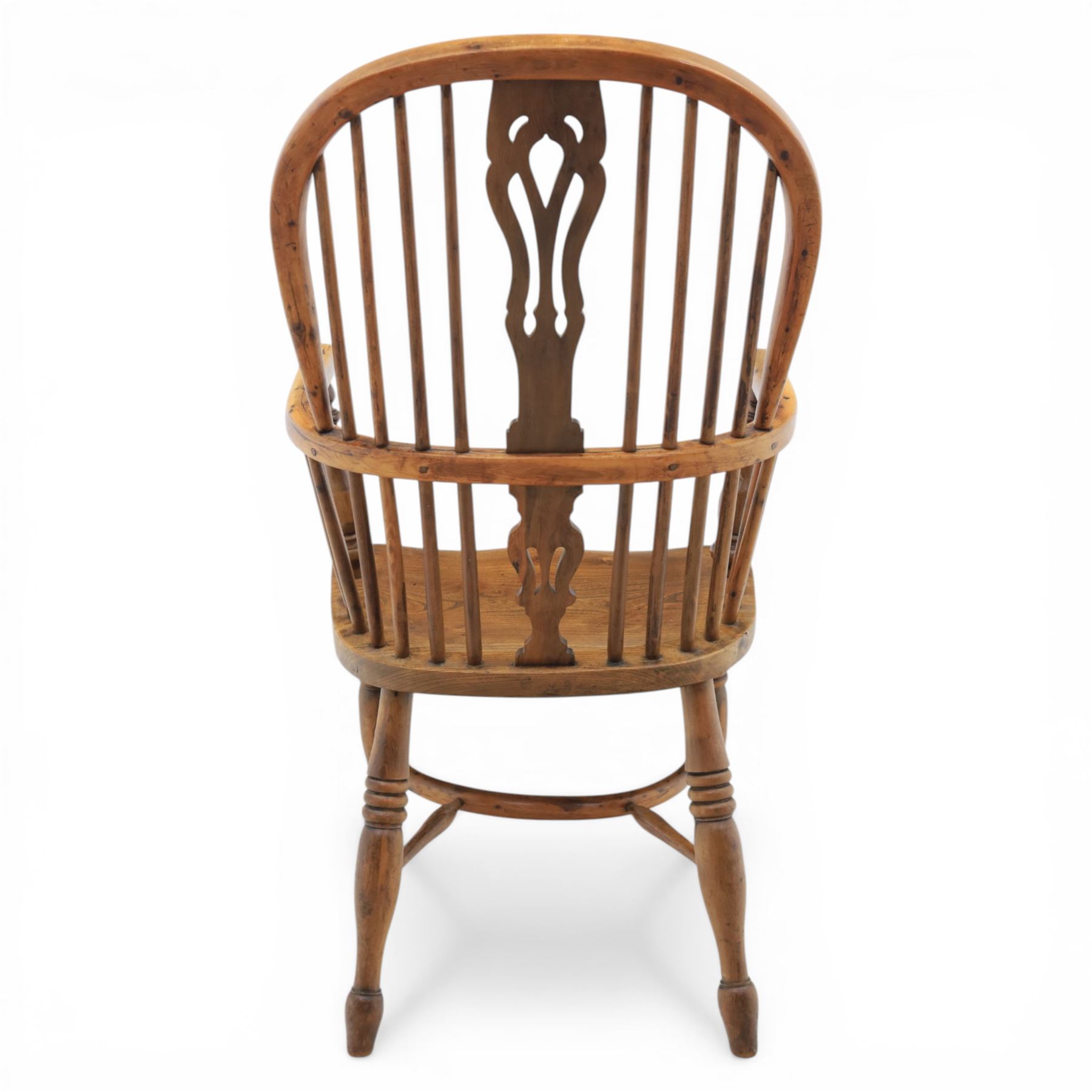 Early 20th century yew wood Windsor armchair, hooped back with spindle supports and shaped pierced central splat, solid seat with shaped edge, turned arm supports, on turned legs united by crinoline stretcher