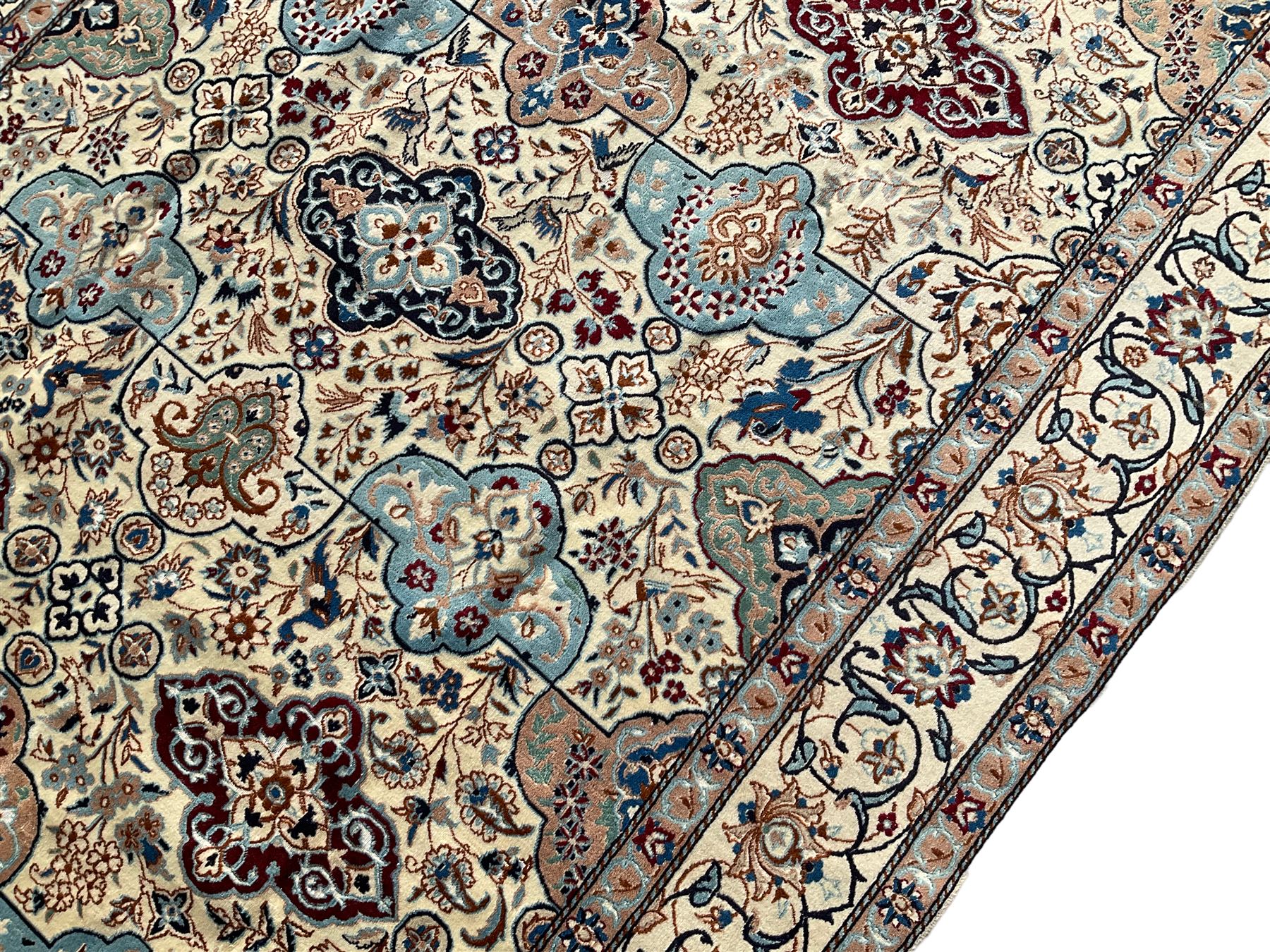 Persian Nain ivory ground rug, wool with silk inlay, the field decorated with stylised gul motifs with palmettes surrounded by interlacing foliate patterns, the guarder border decorated with repeating flower heads and scrolling vines