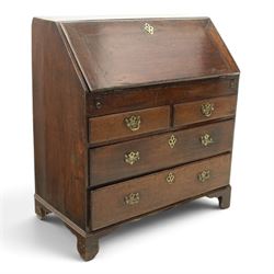 Georgian oak bureau, fall front with pierced brass escutcheon and handles, revealing a fitted interior, above two short over two long drawers, raised on bracket feet
