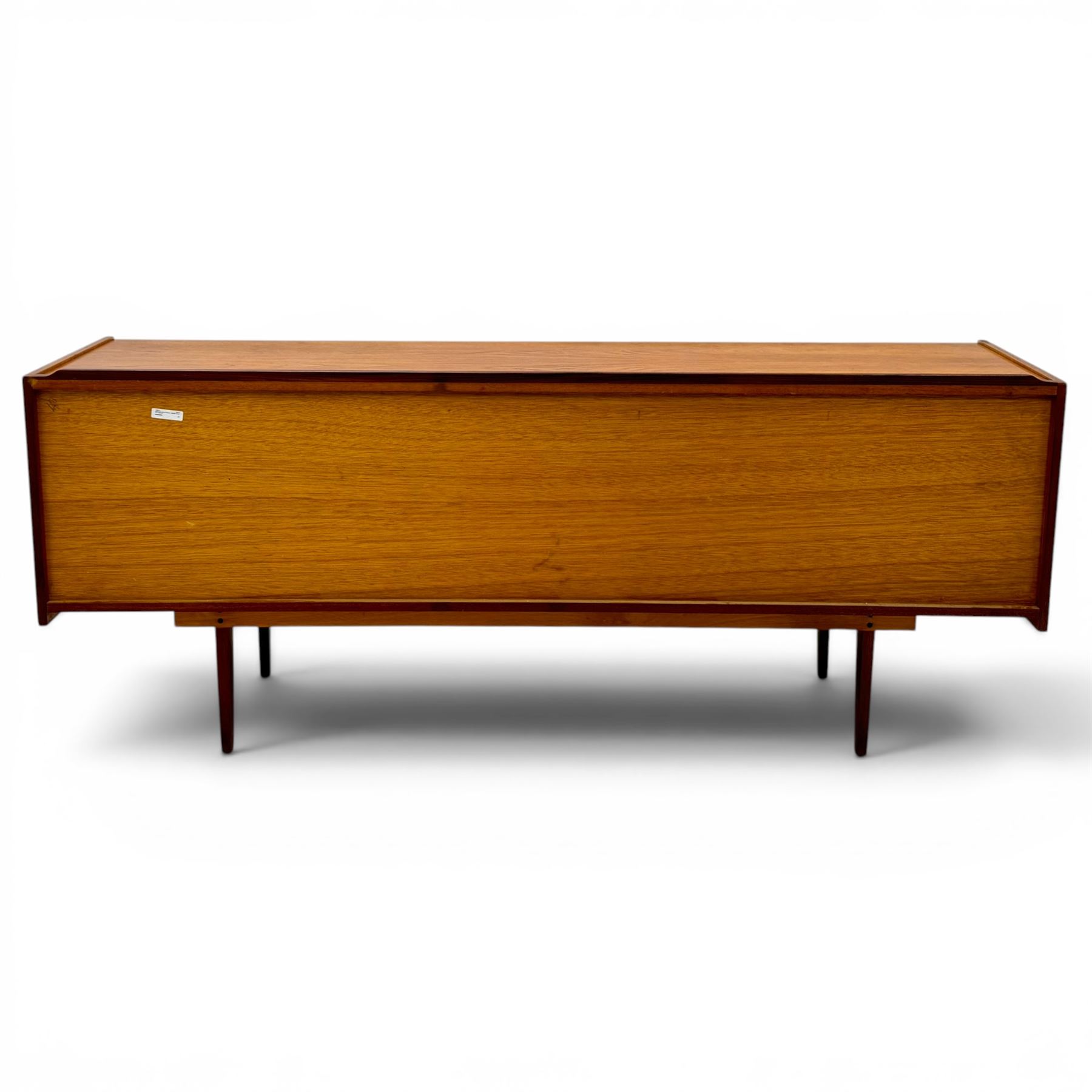 BCM (Bath Cabinet Makers) - mid-20th century teak sideboard, rectangular top with back gallery, left hand side fall front cupboard, centre cupboard opening to reveal a shelved interior, the right side with a bank of three drawers one fitted for cutlery, raised on inset tapering supports