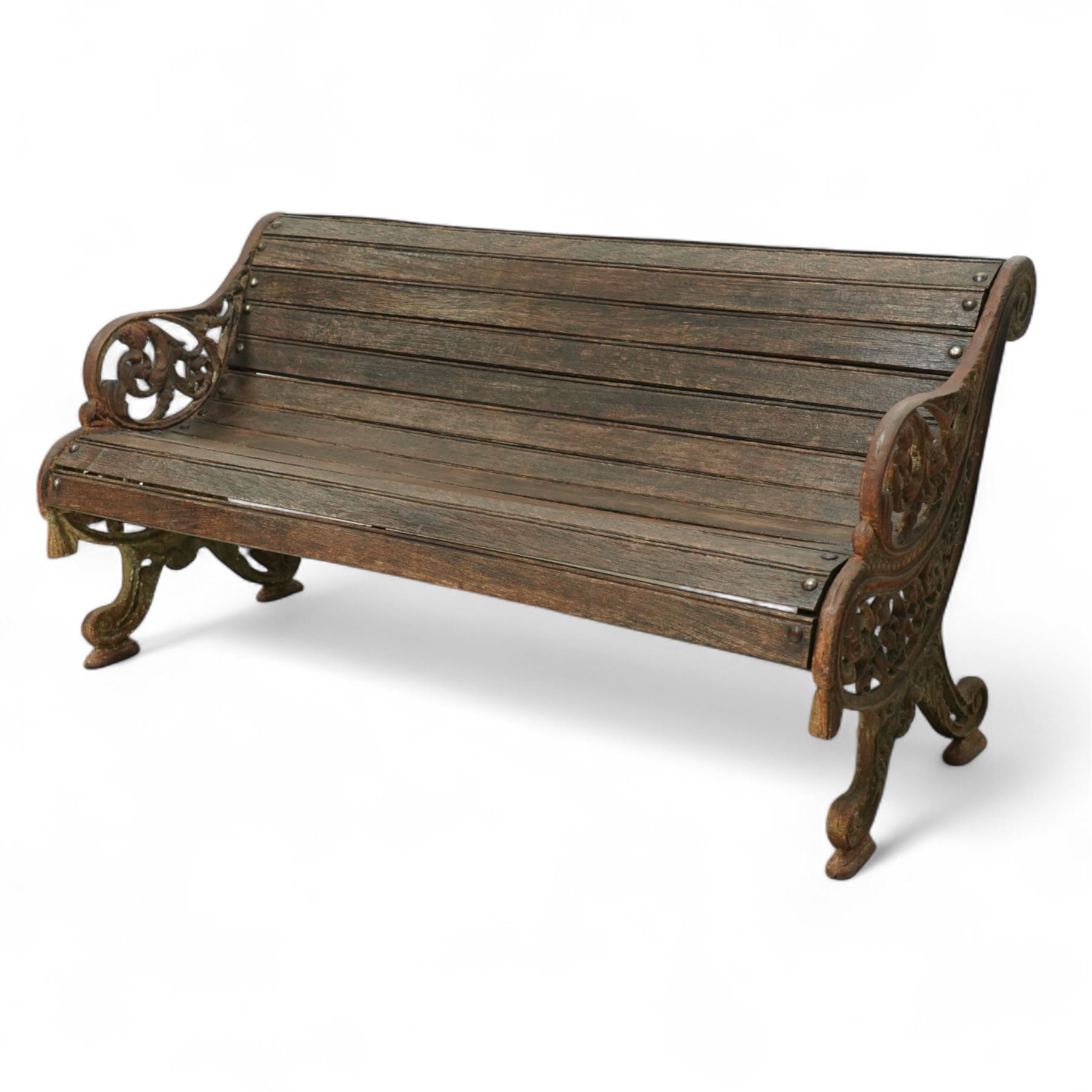 19th century oak and cast iron garden bench, shaped back and seat formed from curved wooden slats secured with dome rivets, pierced cast iron supports with foliate decoration 