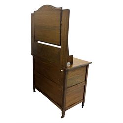 Early 20th century Arts and Crafts oak dressing chest, the arched mirror flanked by floral marquetry inlaid uprights above a shelf and drawer, over three long drawers with square hammered metal plates and circular pulls, on slender supports with castors