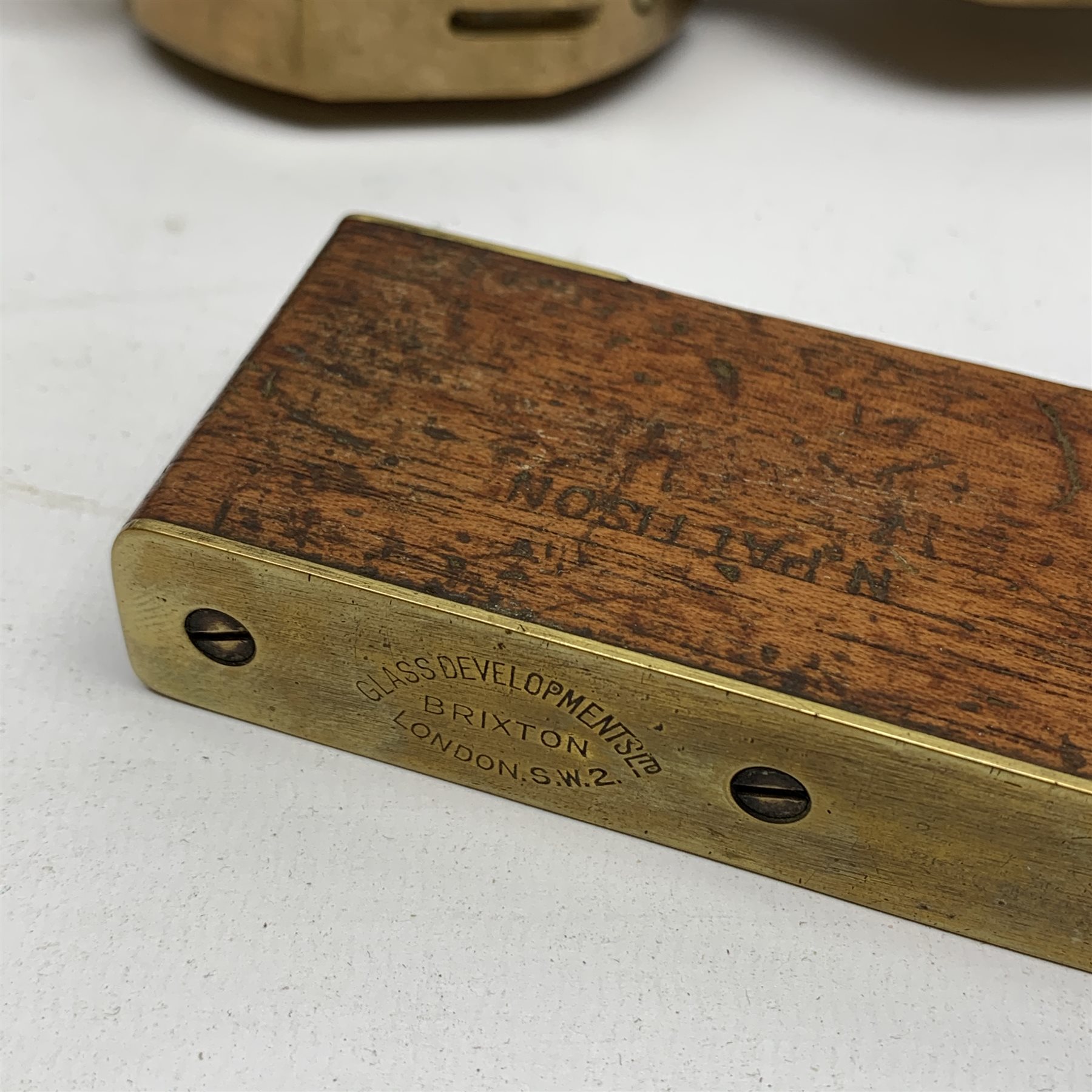 Brass Natural Sine type compass with spirit levels to the dial, bears name of Stanley, D8cm, in earlier mahogany box; brass pocket sextant of drum shaped form, the screw top marked Stanley London; small brass cased compass with pedestal tripod base; and Glass Developments Ltd. hahogany and brass spirit level L31cm (4)
