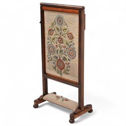 Early to mid-19th century rosewood fire screen, lift-up needle work panel decorated with stylise floral pattern, moulded frame on platforms, lobe carved bun feet