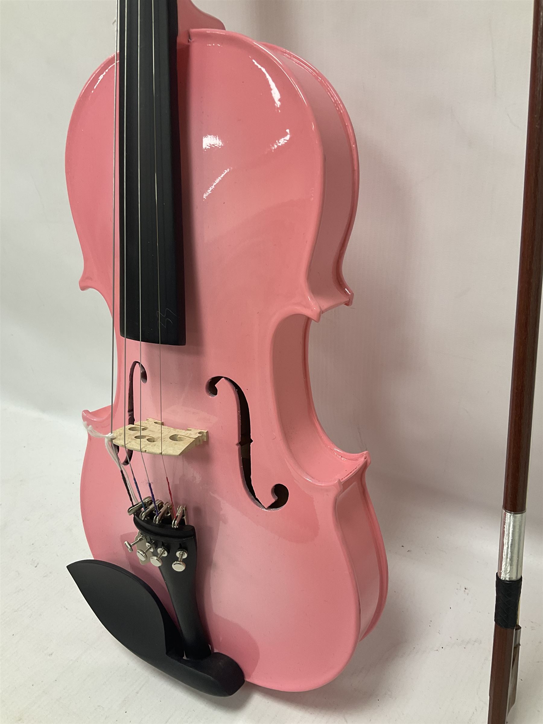 Zest full size pink violin, with a solid wood body and maple head, with matching pink bow and two further bows, in a hard case Length 60cm