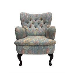 Mid-20th century wingback armchair, upholstered in soft blue floral patterned fabric with button-tufted backrest and curved arms and raised on cabriole supports