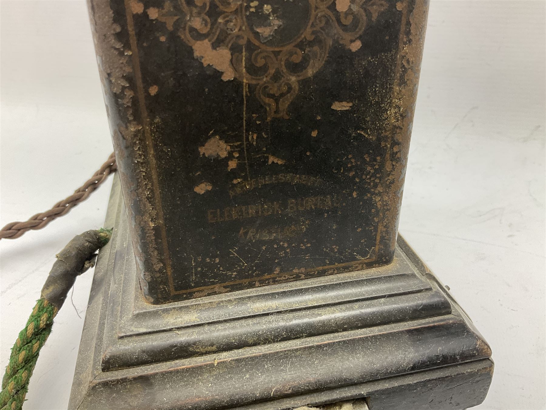 Early 20th century Danish desk telephone inscribed The Ericsson Bell Telephone Co. Glasgow to one side and Aktieselskabet Electrisk Bureau Kristiansand to the other, ebonised wooden top with handset on brass cradle. black japanned tin centre section bearing Hull Corporation Telephones Department crest, side cranking handle and ebonised wooden base H30cm  