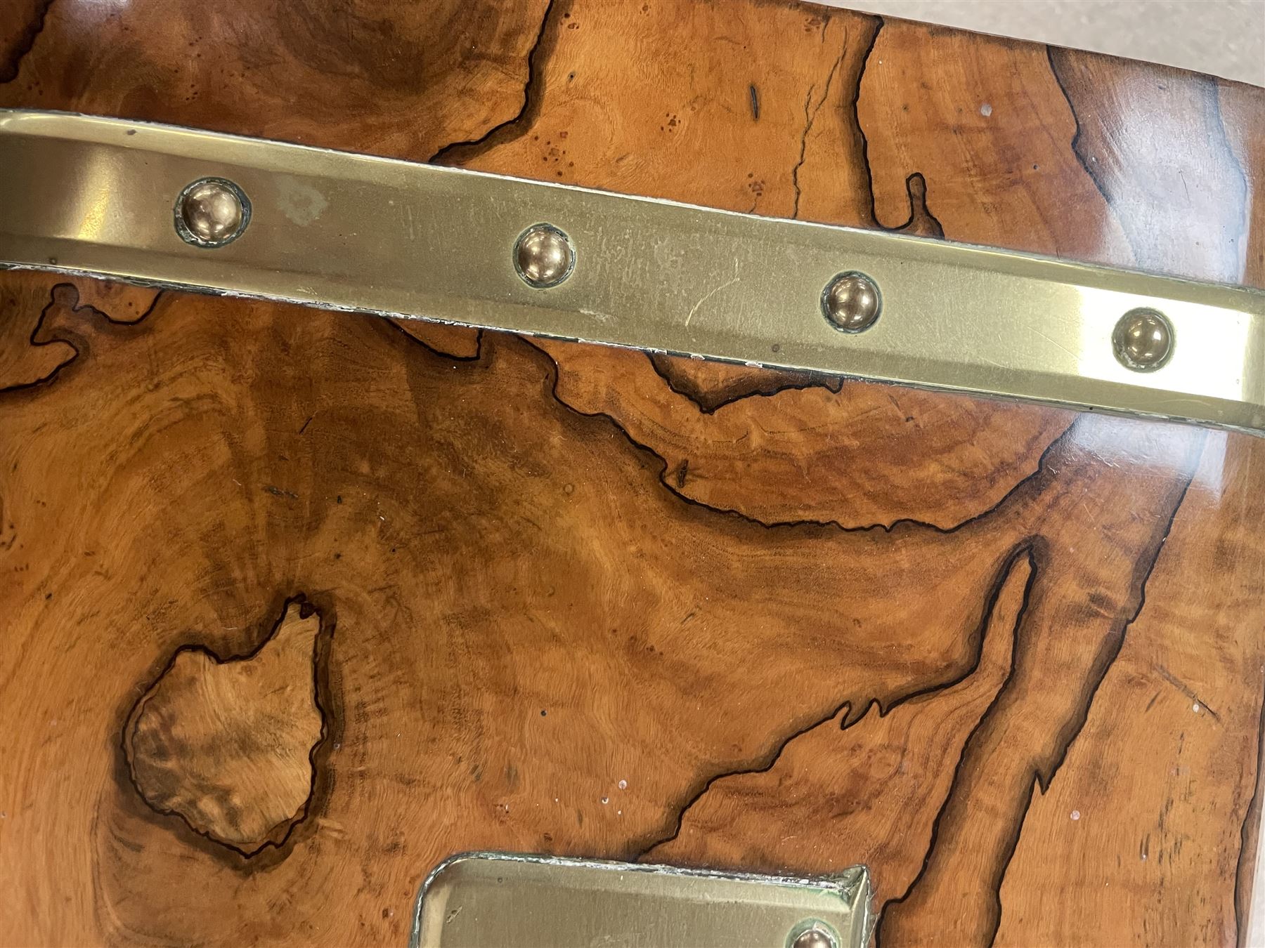 19th century walnut and brass bound games compendium box, painted to enhance the grain, of rectangular form, the hinged opening cover with rounded sides, central brass cartouche with engraved lion crest, and brass riveted straps, opening to reveal a red leather and blue silk lined compartmented interior, with fold-down games board, and lift-out tray containing playing cards, ebony turned dice towers, white and red stained bone draughts, and chess pieces, ivory dice, and ivory and ebony whist markers, and brass bezique board, cribbage board and markers, H15cm W32cm D24cm
This lot has been registered for sale under Section 10 of the APHA Ivory Act