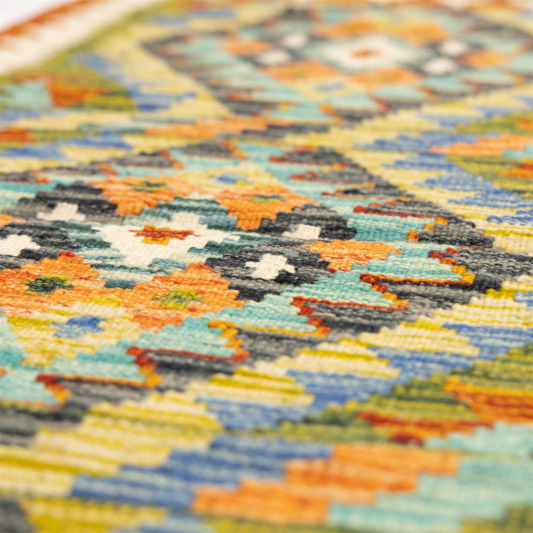 Two Chobi flatweave kilim runners with a repeating stepped diamond medallion design in live green, rust, teal, purple, and ivory, framed by chevron and geometric borders, (2)