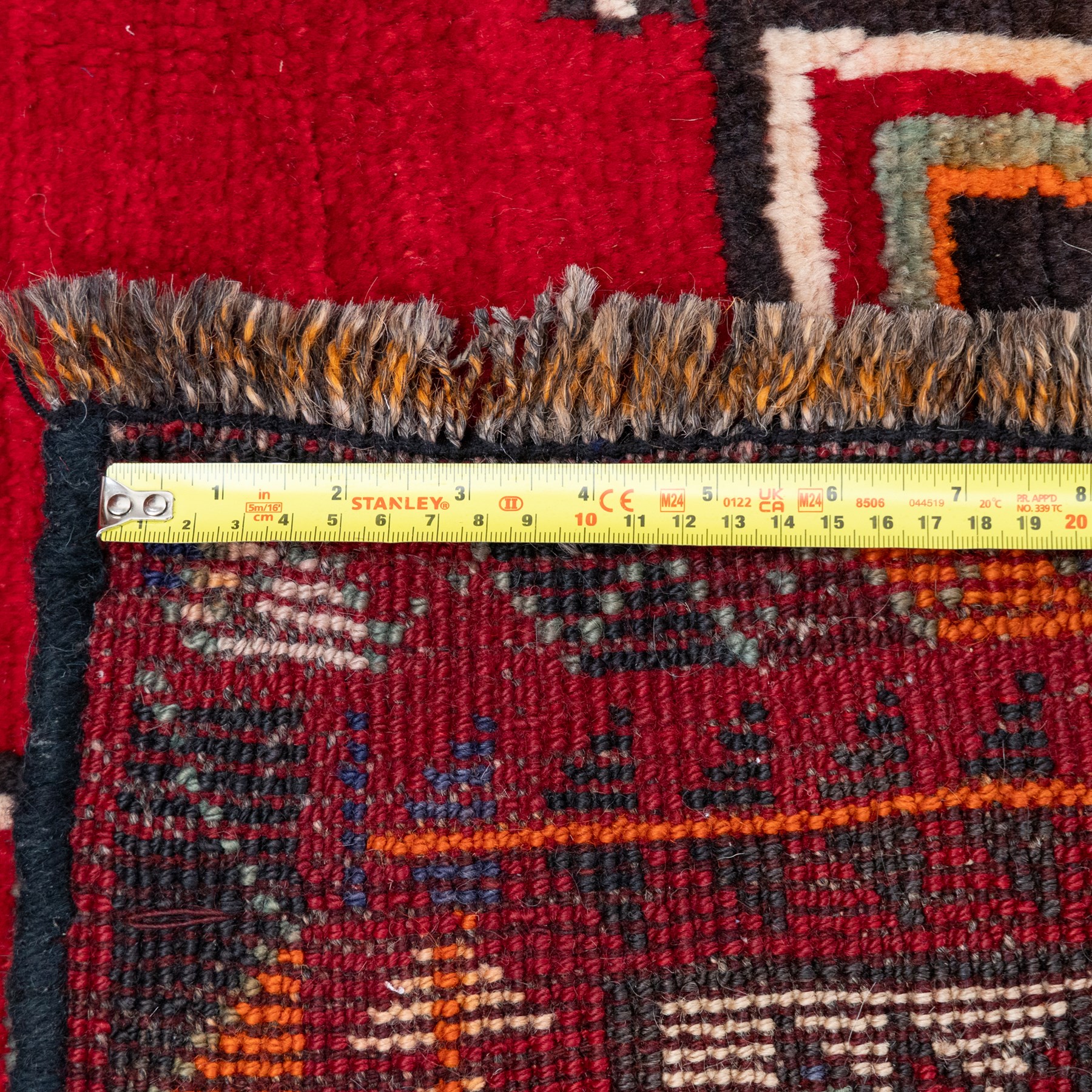 South-west Persian Lori rug, the red field centred by four linked stepped cruciform medallions with polychrome diamond centres, enclosed by a blue ground octagonal motif border, ivory angular meander band and red geometric outer border