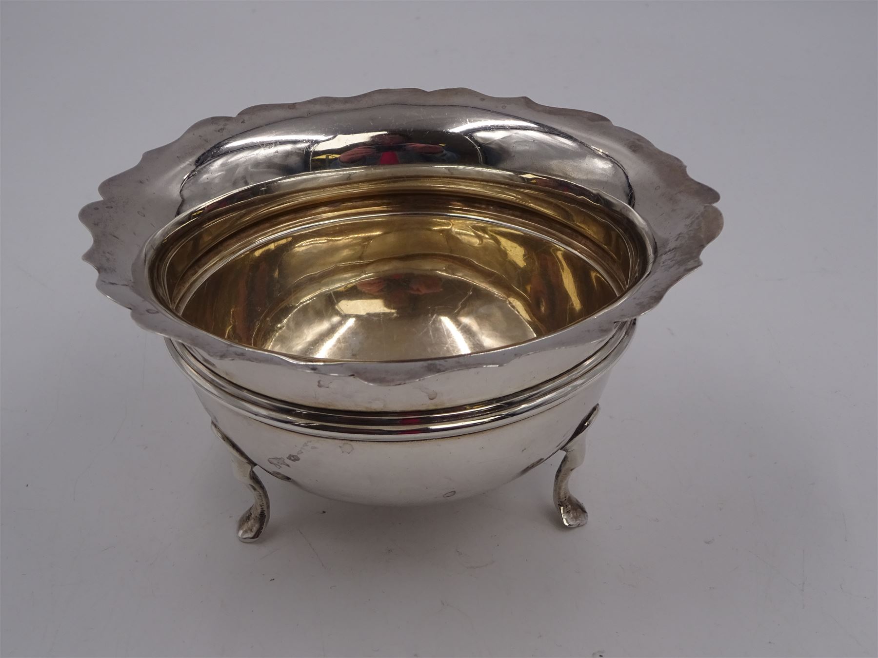 1930s silver open sucrier, of circular form with girdle, with shaped rim and upon three pad feet, hallmarked Birmingham 1931, together with silver fork and spoon set, decorated in relief with foliate pattern to handles, hallmarked William Devenport, Birmingham 1896 to blades and Sheffield 1896 handles