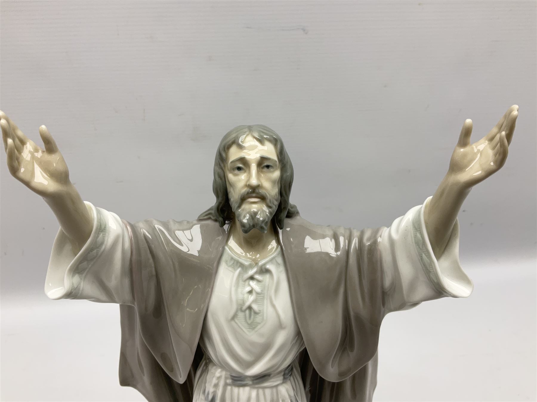 Lladro figure, The Loaves and Fishes, modelled as Jesus Christ with arms raised standing beside a basket of loaves and a basket of fish, sculpted by Salvador Furió, with original box, no 5896, year issued 1992, year retired 1997, H35cm