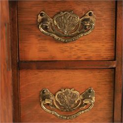 19th century oak table top smokers cabinet, with carved foliate pediment, the two beveled edge glass doors opening to reveal a fitted interior, with four drawers and fitted brass of pipe holders to each door, H46cm