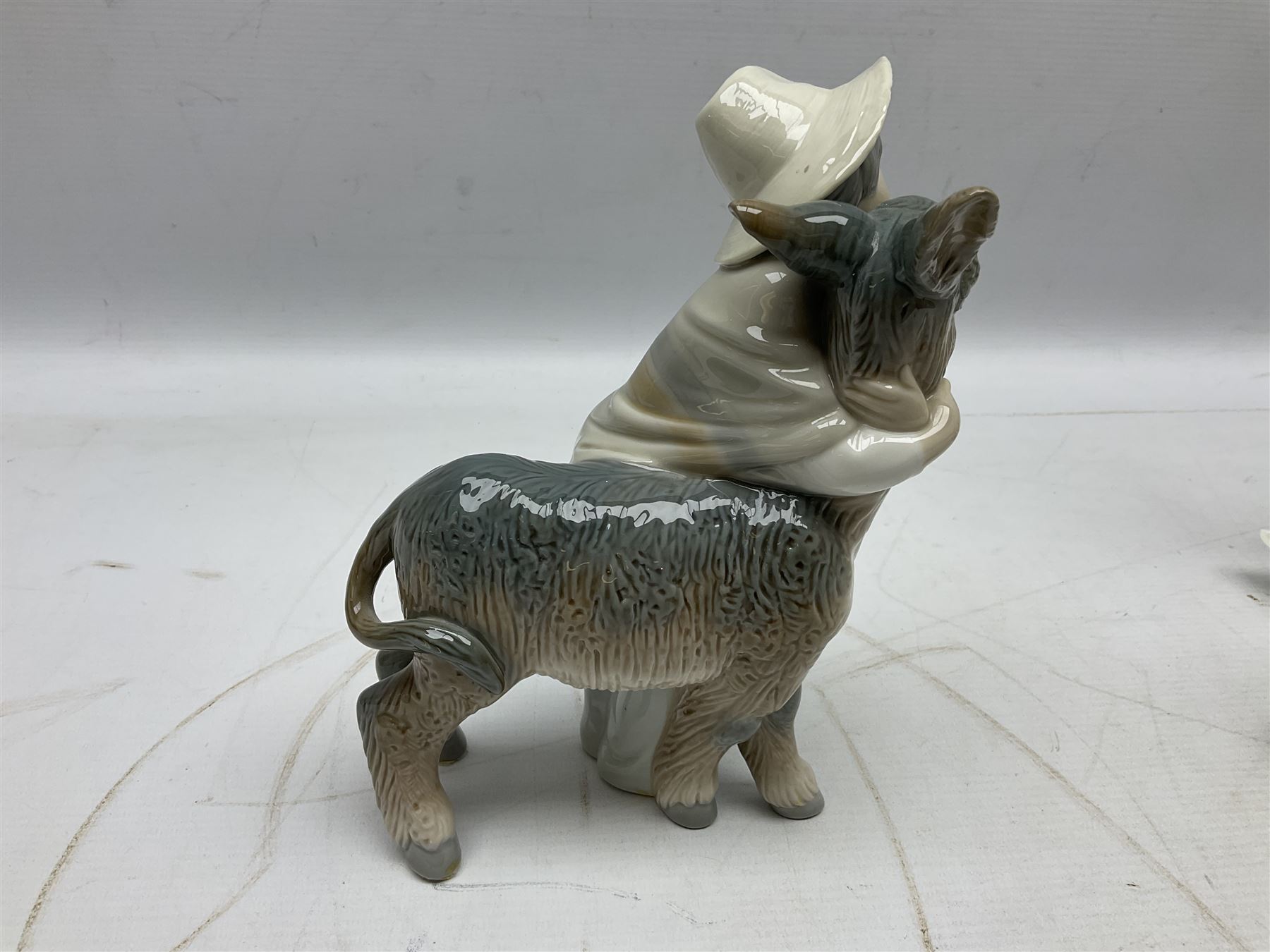 Seven Lladro figures, comprising Playful Puppy no 9135, Platero and Marcelino/Boy Hugging Donkey no 1181, Mini Seal Family no 5318, Attentive Polar Bear no 1207, Seated Polar Bear no1209, Eskimo Boy with Pet no 5238 and Girl with Geese no 1035, together with Nao goose