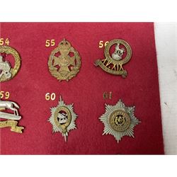 Twenty cap badges including Welsh Guards, Kings Royal Irish Hussars, York & Lancaster,  Loyal Suffolk Hussars, North Stafford, Durham Light Infantry, Cheshire, West Yorkshire, Norfolk, South Wales Borderers, Dorsetshire etc; mounted on a board for display