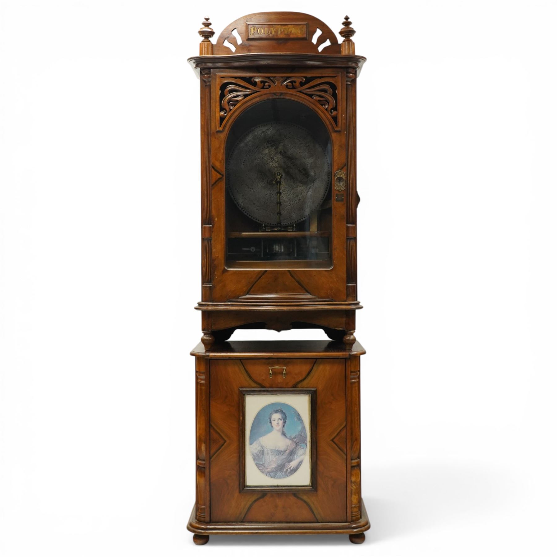 Late 19th century coin operated floor standing Polyphon, the shaped cornice marked 'Polyphon' with eleven 50cm discs in a walnut case with glazed upper section, the coin slot marked '1 Penny', the lower section with fall front for disc storage and inset with a portrait print and on compressed bun feet H230cm x W76cm x D46cm with a number of old pennies