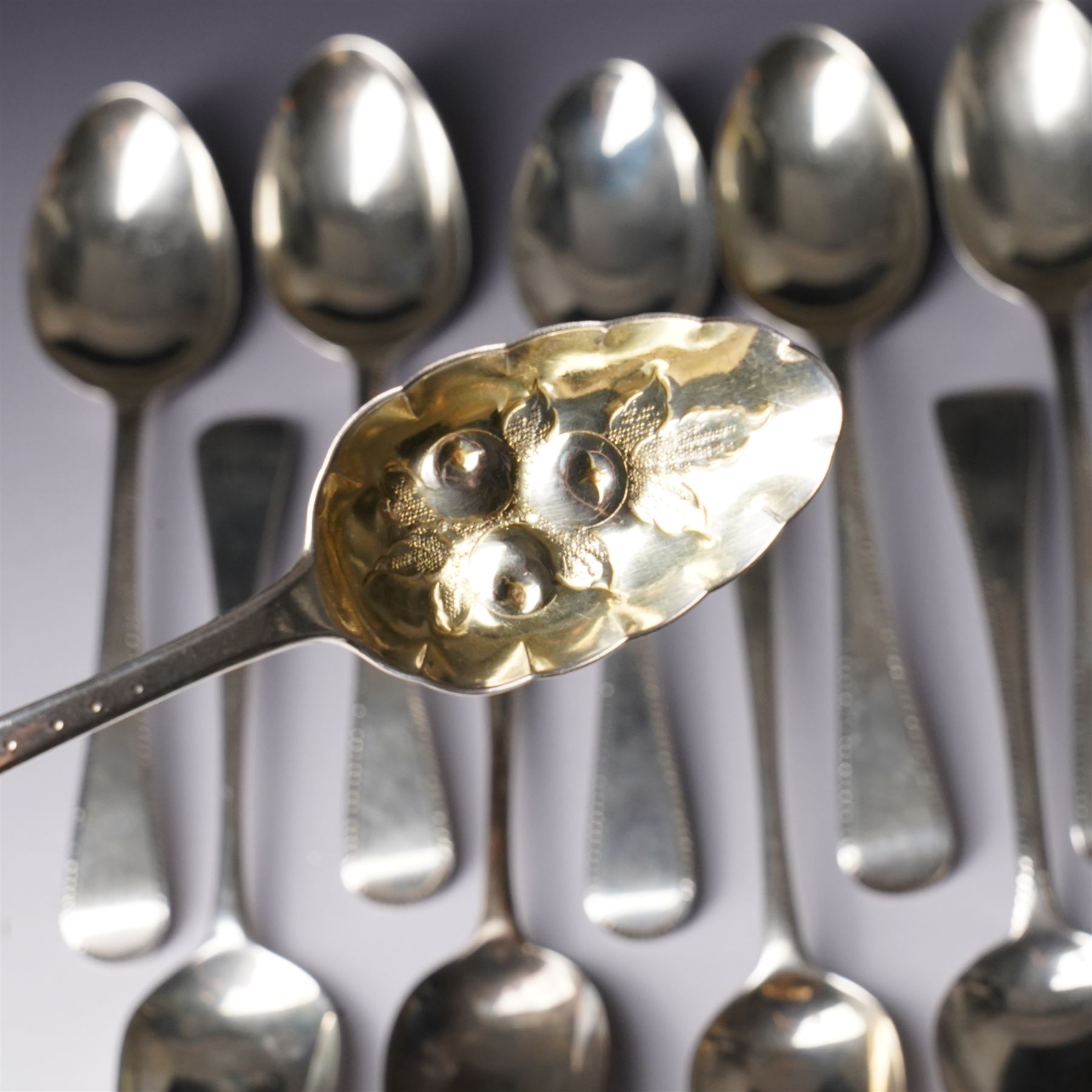 Set of six George III silver dessert spoons with bright cut stemsLondon 1818 Maker Thomas Wallis II and Jonathan Hayne, three other silver dessert spoons and a silver berry spoon with gilded bowl (10)