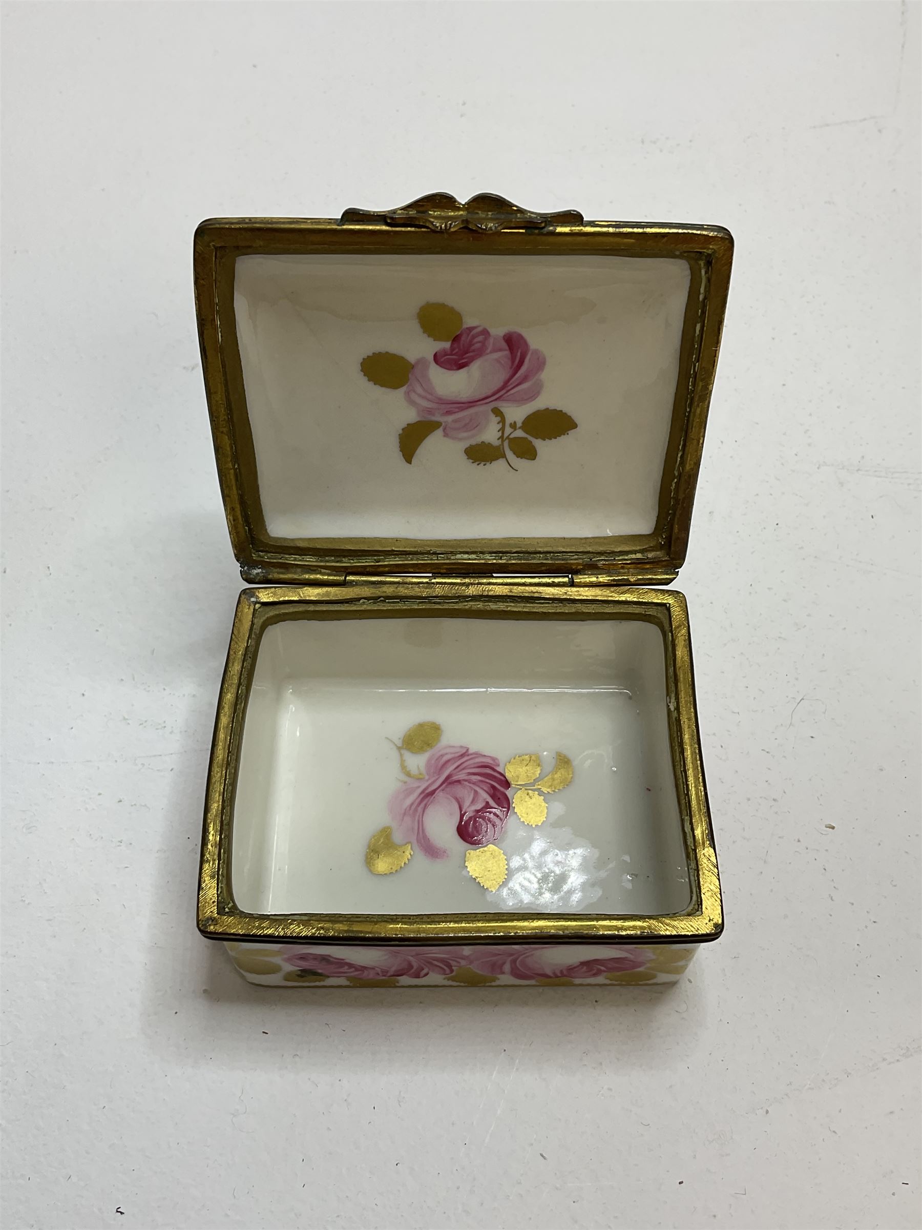 Early 19th century Swansea box of rectangular form, densely decorated with painted pink cabbage roses and gilt foliage upon plain ground, the hinged lid opening to reveal interior painted with two further roses upon plain ground, marked Swansea. in gilded lettering beneath, W7cm H3.5cm D5.5cm