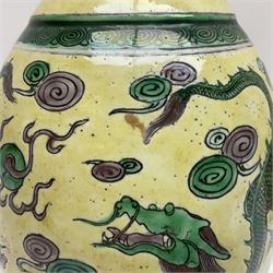 20th century Chinese Famille Verte vase, of slender ovoid form with tapering neck and flared rim, decorated with green and grey enamel with dragons chasing flaming pearls amongst auspicious clouds upon a yellow ground, H30cm