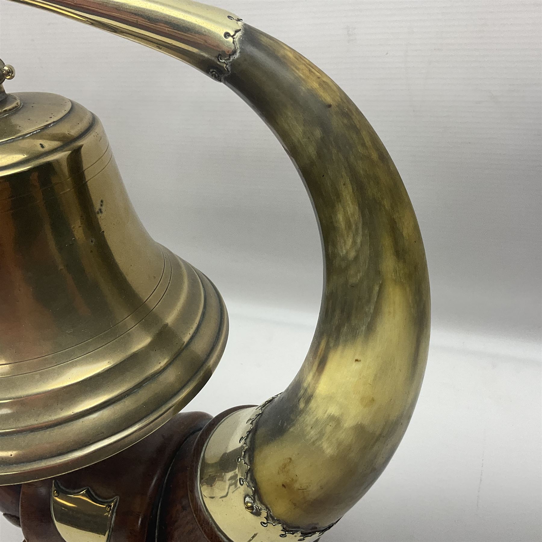Early 20th century oak and horn dinner bell, the silvered bell suspended from a pair of cow horns, with silver plated mounts and blank shield shaped cartouche, upon square base, H37cm