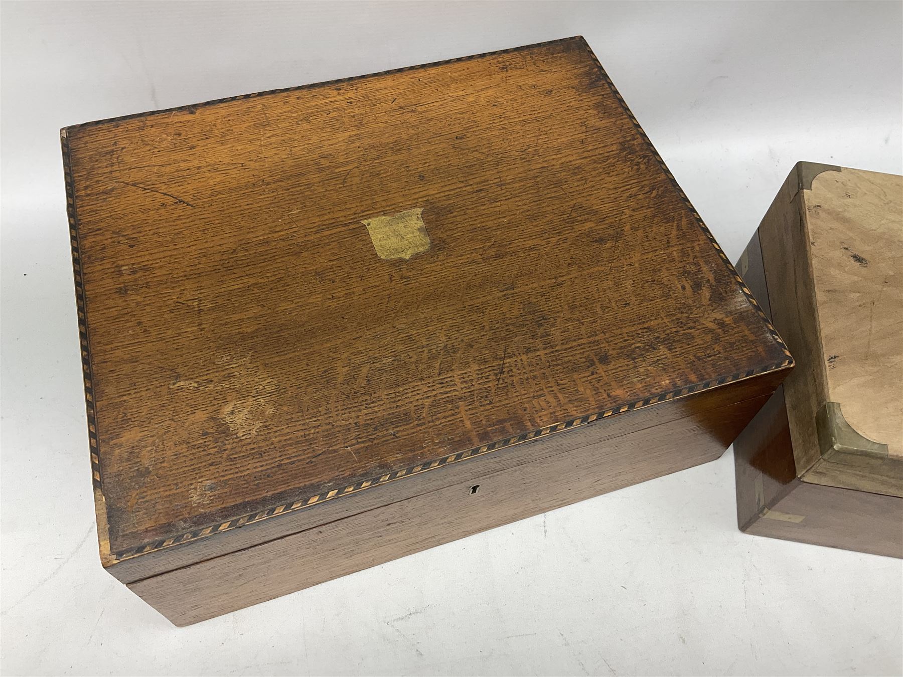 Early 20th century oak canteen box, the hinged lid decorated with marquetry banding and brass shield shaped plaque lifting to reveal red lined interior with lift out tray,  together with a walnut writing slope for restoration, largest L41cm, H44.5cm D33cm