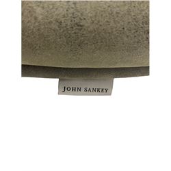 John Sankey - low armchair, buttoned back upholstered in tartan patterned fabric with contrasting grey leather, raised on turned and ebonised front feet with brass and ceramic castors, with matching foot stool