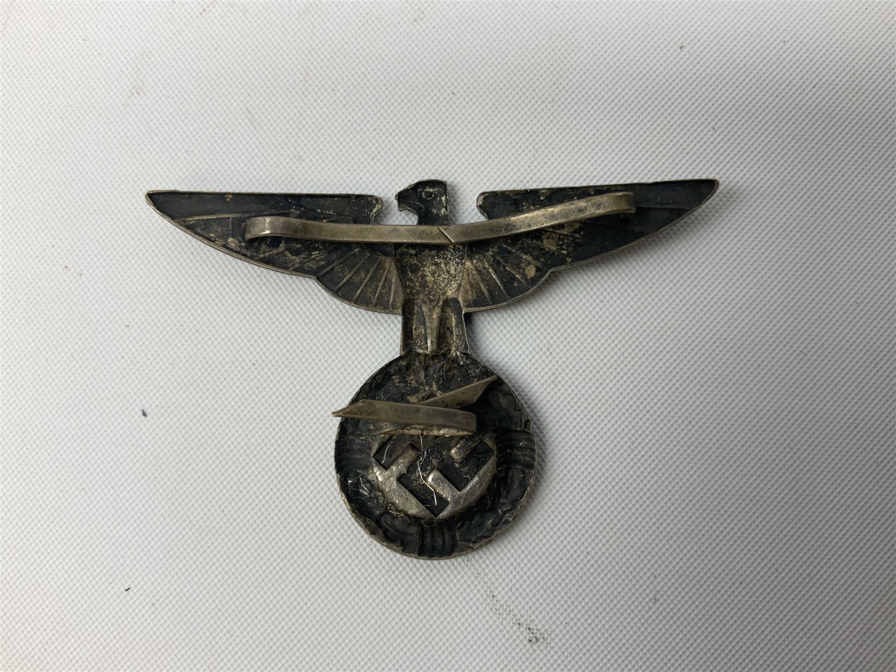 Three WW2 German visor cap badges comprising Police eagle, Political leaders eagle and Norwegian Quisling Party; all with fixings; and WW2 Polish visor cap badge (4)