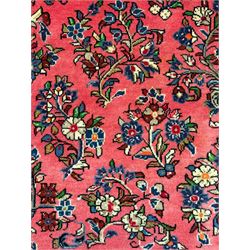 North West Persian Sarouk peach ground rug, the field decorated with floral bunches, pale ground border with repeating flower head motifs within guard stripes 