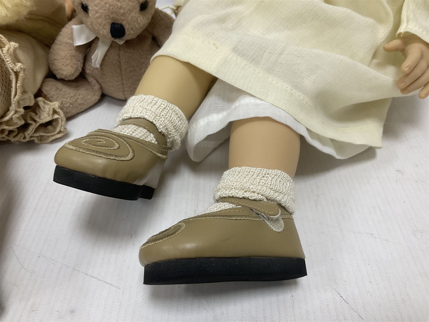 Two Zapf Creation limited edition designer collection dolls, by Brigette Paetsch, the first example with faux suede jacket, red jumper and denim skirt, no. 460, the second example 'Linda' in white dress with teddy bear accessory, no. 785, each signed B Paetsch, tallest L60cm