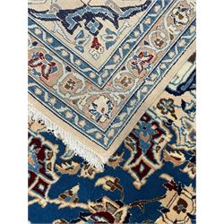 Persian Kashan blue ground rug, central floral rosette medallion within a field of swirling branches and palmettes, the border with trailing pattern interspersed with stylised plant motifs