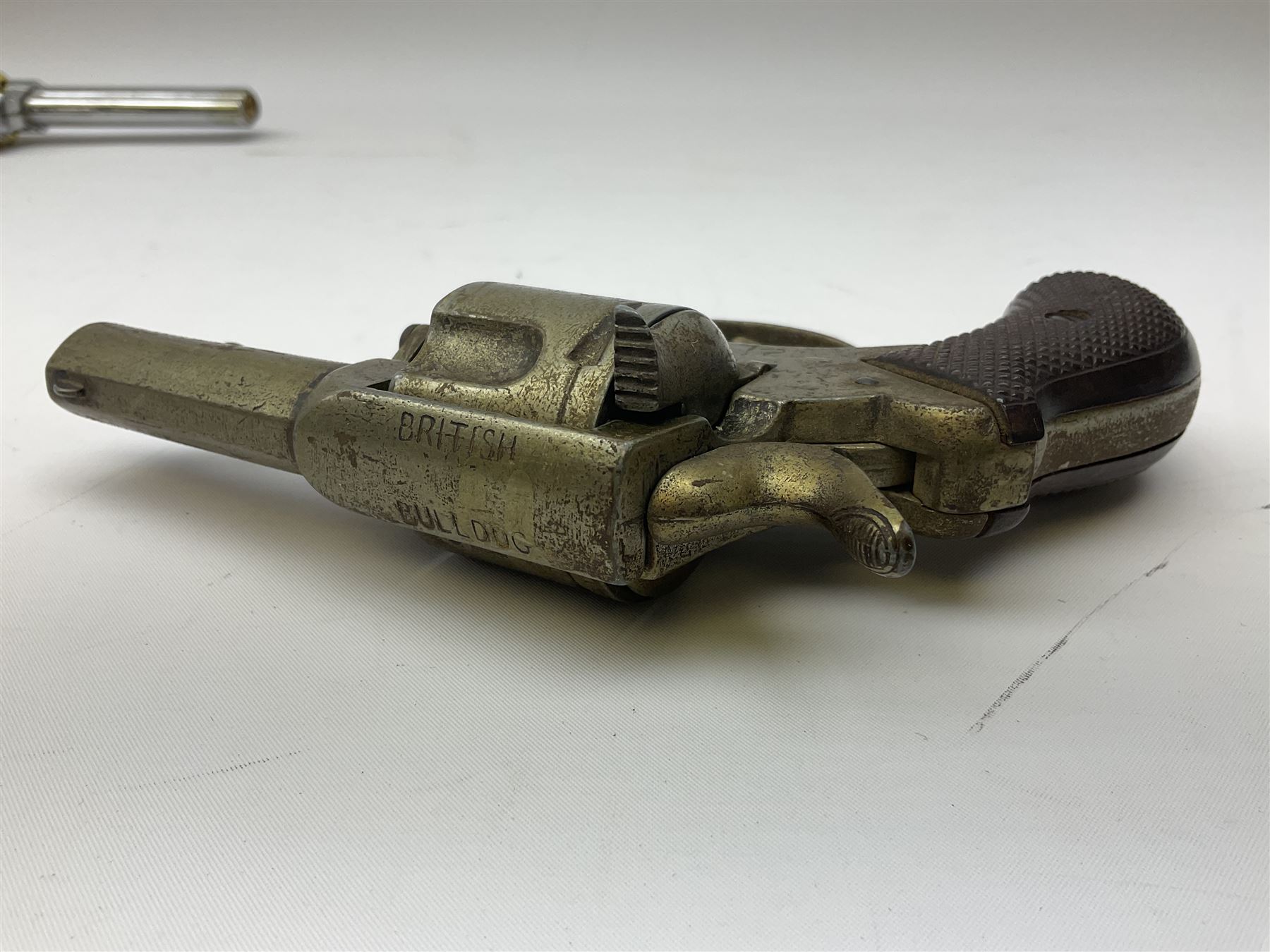 Early 20th century Flobert 5mm blank firing revolver with six-shot chamber, top venting, nickel plated with folding trigger No.118 L12.5cm overall; replica non-firing 'British Bulldog' revolver; and Windproof gas lighter inscribed 'Revolver-99 Spring and Autumn' in holster marked 'Star-Line'