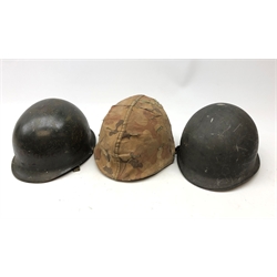  WW2 American M1 Steel helmet, with camouflauged cover, another with net, interior marked F.Ae/LM J.M.L '60, U.M.A.L, another  interior pencilled Weaver, all with liners and chinstraps (3)  