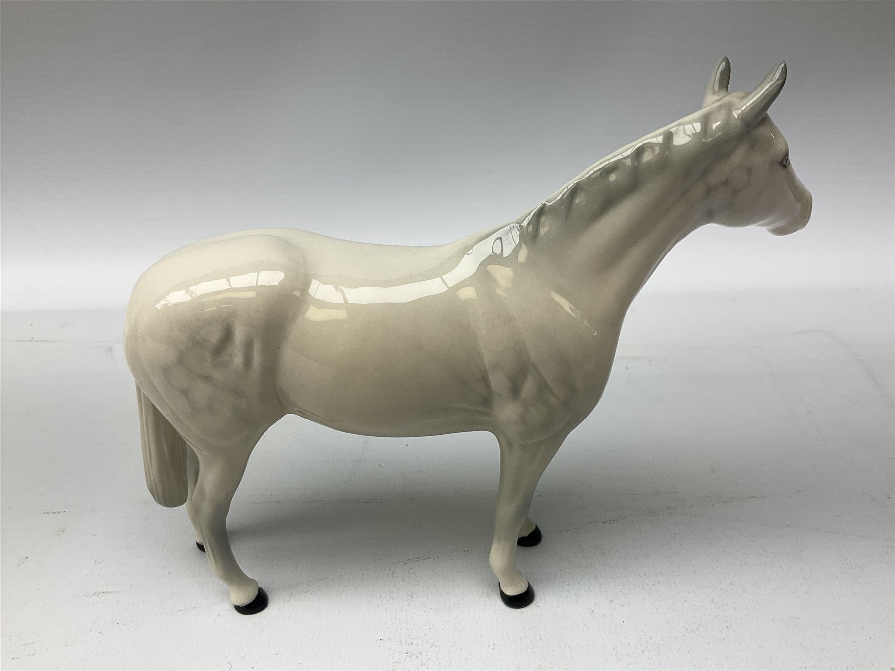 Collection of Beswick horses, including grey horse no.701, palomino foal no 836, grey stocky jogging mare no.855 etc, together two Royal Doulton horses, (8)