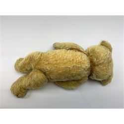 Merrythought Hygienic Toys large 'Magnet' teddy bear c1930s with plush body, swivel jointed head with glass eyes and vertically stitched nose and mouth and jointed limbs,  celluloid wishbone button to right ear and stitched label under right pad H22