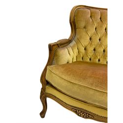Late 20th century beech framed three seat settee, shaped back carved with flower heads, upholstered in buttoned fabric, on cabriole supports 